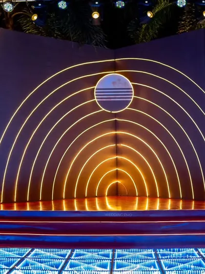 A stage that was out of this world. The orbit-inspired concentric neon arches created a cosmic focal point, set инноваate an infinity-mirror LED dance floor for a truly immersive experience.