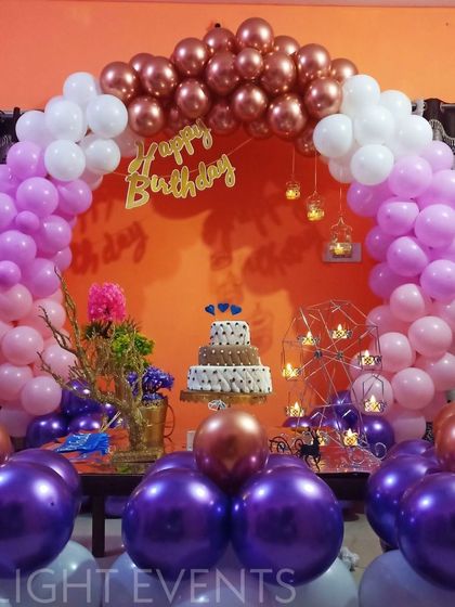 Another look at our popular purple and pink home setup, this time with the birthday cake as the centerpiece. The multi-tiered cake sits perfectly within the colorful balloon arch, showing how we integrate all elements of your party.