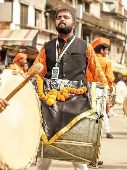 A dhol player lost in the bliss of the rhythm, his eyes closed in a moment of pure 'Vadan Sukh' (the joy of playing).