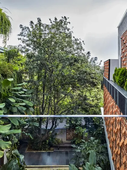 A view from a bridge in Project 58, looking down into a verdant courtyard. The design breaks down the mass of the building, weaving pockets of nature throughout the home to create a sense of living within a garden.