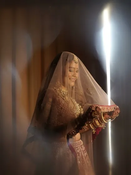 A classic bridal portrait with the veil, creating a soft and ethereal effect that highlights her smile.