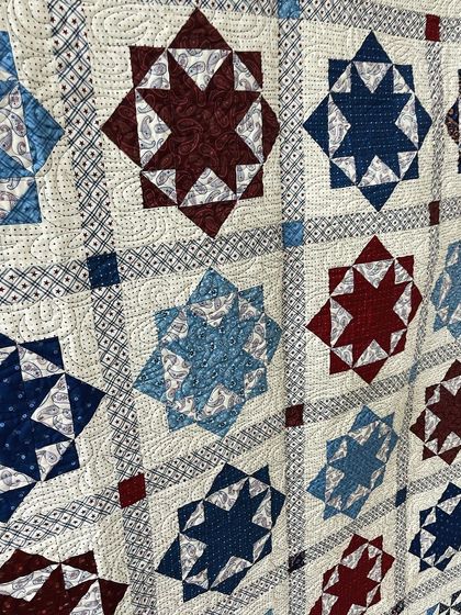 An angled view showing the quilting detail in the sashing and star blocks.