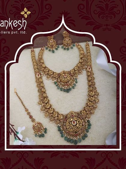 A full temple jewellery bridal set, complete with a choker, long necklace, and maang tikka. The green emerald-like stones add a touch of colour to the antique gold finish.
