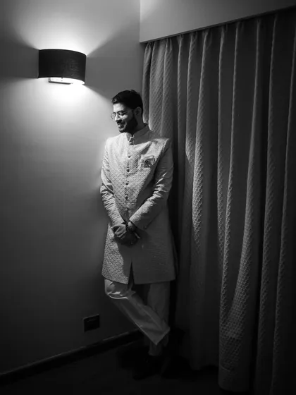 A classic black and white portrait of the groom. His relaxed smile and elegant sherwani are captured beautifully in this timeless and sophisticated shot.