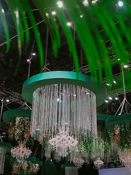 A view of the magnificent hanging chandeliers through lush green foliage, creating the feeling of discovering a secret, magical clearing in an enchanted forest.
