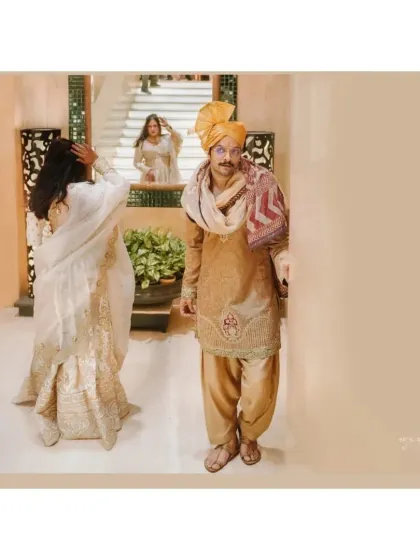 Another perspective of the creative reflection shot, showing the bride adjusting her hair while her reflection and the groom are visible, telling a story within a single frame.