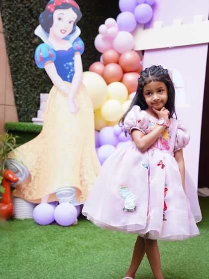 The birthday princess strikes a pose next to a Snow White cutout. Our life-sized characters make for amazing photo companions.