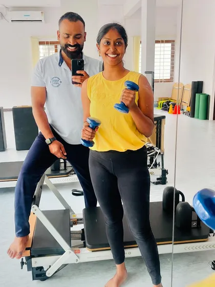 This client is all smiles holding dumbbells after a tough session. That's the spirit!