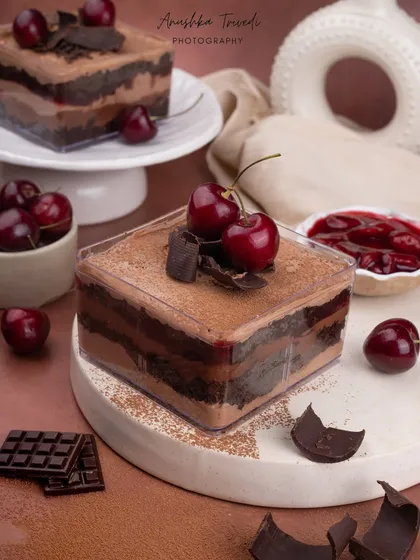 A layered cherry and chocolate tub cake. The dark, rich colours and moody styling give this dessert a very decadent and luxurious feel.