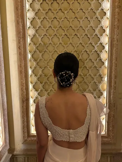 The details make the look. The pearl-adorned bun was the perfect hairstyle to complement the elegant, all-white saree for a sophisticated evening.