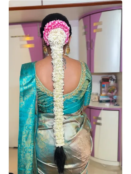 A classic South Indian bridal braid, adorned with fresh mallige (jasmine) and pink flowers. The fragrance and beauty of fresh flowers add such a special touch to a traditional look.