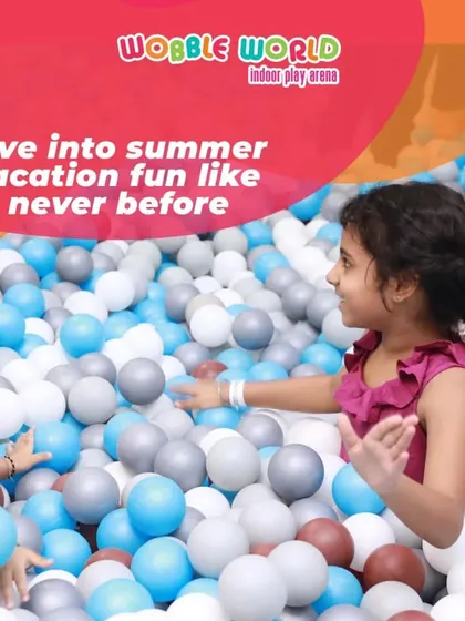 Two little ones enjoying a moment together in the ball pit. It's a great space for toddlers and older kids to play alongside each other safely.