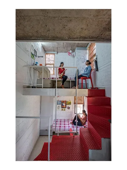 Students occupying the multi-level space in the "Stacked Student Housing" project. The design fosters a sense of personal space even within a shared living arrangement.