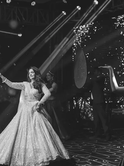 A stunning black and white shot of a bride's solo, capturing her grace and the stage's atmosphere.