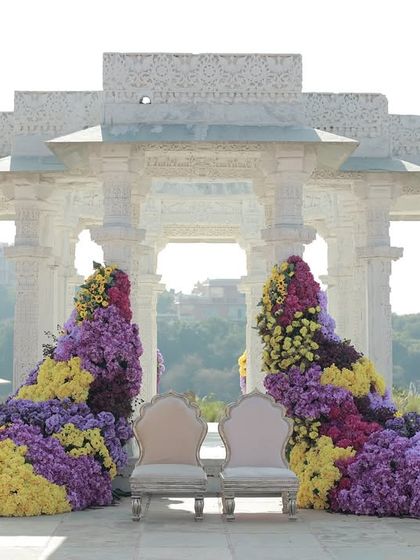 For this Haldi in Udaipur, we used the stunning white marble architecture as a canvas. Cascading arrangements of yellow, purple, and magenta flowers were designed to flow down the pillars, creating a breathtaking contrast.