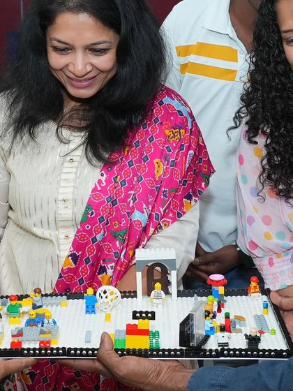 A group admiring a complex LEGO creation. Our workshops often include collaborative builds, where participants can contribute to a larger, impressive final product.