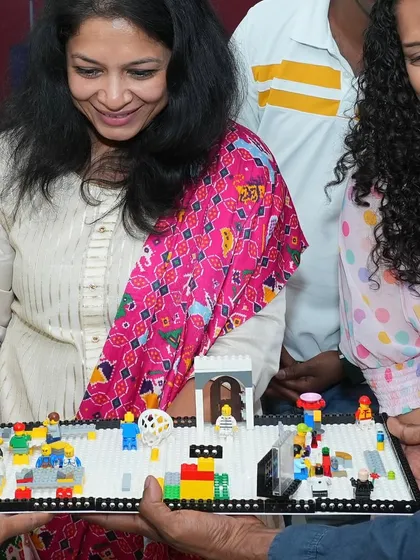 A group admiring a complex LEGO creation. Our workshops often include collaborative builds, where participants can contribute to a larger, impressive final product.