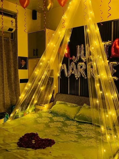 Another angle of the romantic "Just Married" room, highlighting the warm lighting and the heart-shaped petal arrangement on the bed.