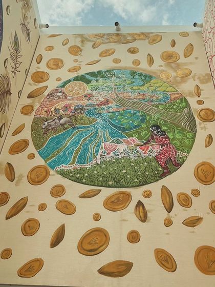 The installed "Marudham" panel, surrounded by painted gold coins that symbolize prosperity and the fruits of labor. This shows the final look of the panel as part of the larger room installation.
