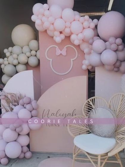 A modern and chic take on a classic character. This Minnie Mouse themed party uses a sophisticated pastel pink and neutral palette with a subtle Minnie silhouette and a stylish rattan chair for a trendy celebration.
