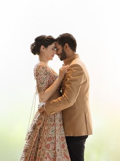 An intimate portrait against a brightly lit background. The soft focus and close embrace create a dreamy, romantic image that perfectly captures the connection between Wirla and Jibran.