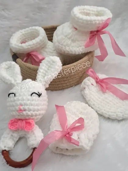 The full bunny-themed gift set, featuring a bunny rattle, soft booties, and matching mittens, all in white with delicate pink ribbon accents.