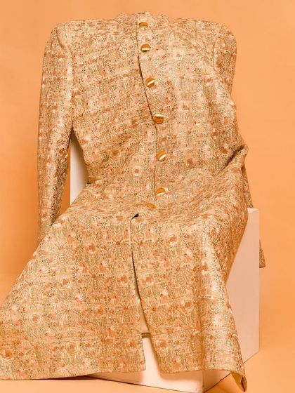 This sherwani jacket is adorned with beautiful golden and orange floral embroidery. It’s a radiant piece that brings a spark of color and artistry, perfect for celebrating in style.