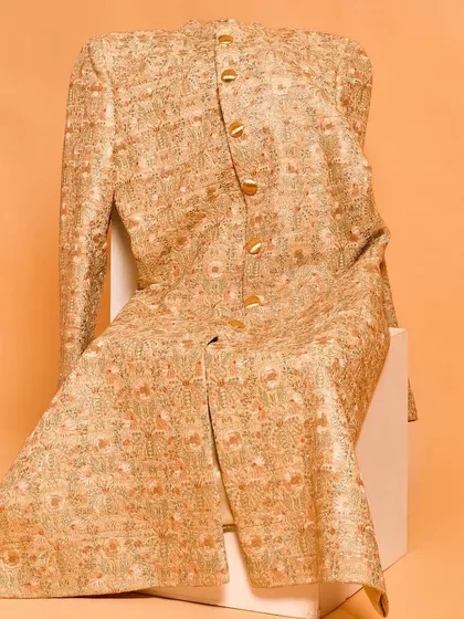 This sherwani jacket is adorned with beautiful golden and orange floral embroidery. It’s a radiant piece that brings a spark of color and artistry, perfect for celebrating in style.