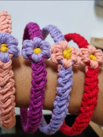 A collection of my floral headbands on my arm, showing the different color combinations available, like peach, purple, and red.