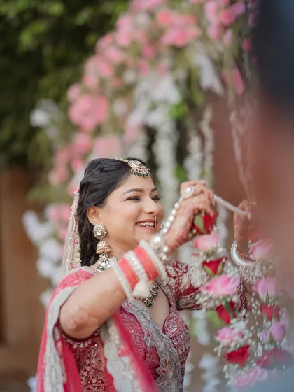 A candid shot of the bride laughing with joy during the Varmala ceremony. These unposed, happy moments are what make your wedding photos truly special and personal.