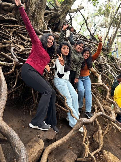 Friends having fun on the giant tree roots in Kodaikanal.