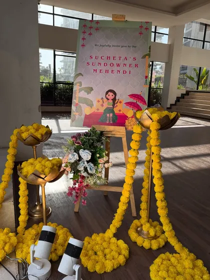 A personalized welcome sign for a 'Sundowner Mehendi'. We surrounded the sign with traditional marigold garlands and brass urlis to create a warm, inviting entrance.