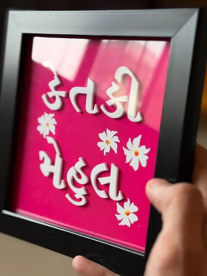 A handheld view of the custom Gujarati nameplate, showcasing its compact size and vibrant colors.