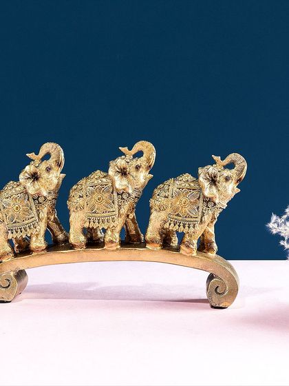 A similar trio of elephants, this time finished in an antique gold with detailed carvings. This piece brings a sense of tradition and worldly charm to your home decor.