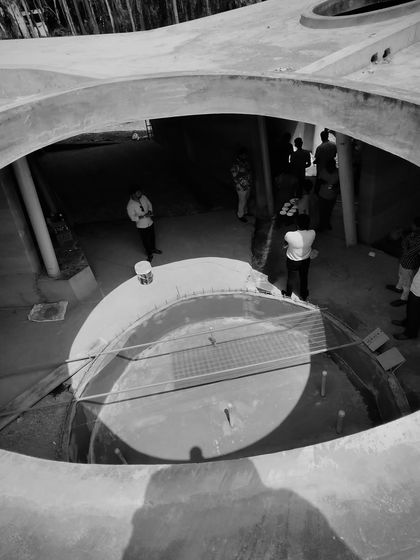 Looking down into the central oculus of the resort's main building, capturing the interplay of light, shadow, and human scale.