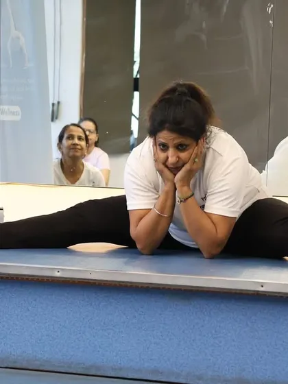 A lighthearted moment during a flexibility session. Even challenging poses can be approached with a smile.