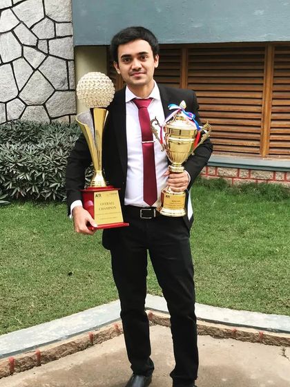 Holding the Winner and Overall Champion trophies from my law school days. Facing my fear of public speaking in these competitions built the confidence I now use to advocate for my clients in court.
