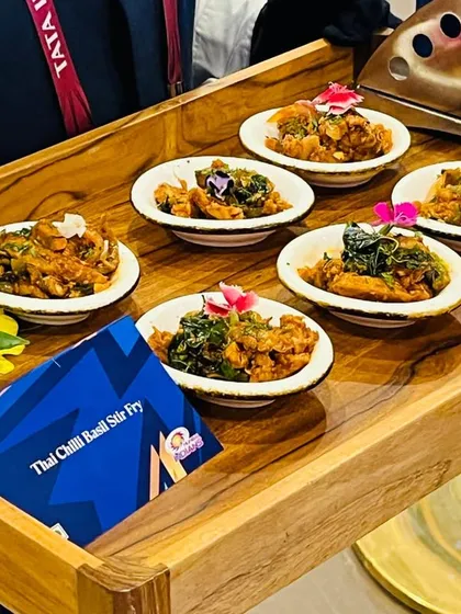 A tray of Thai Chilli Basil Stir Fry being served at an IPL match. Our pass around appetisers are designed to be delicious and easy to eat, perfect for a dynamic event setting.