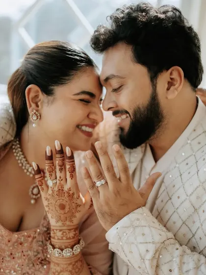 A close-up of the happy couple. Her simple yet chic hairstyle keeps the focus on her radiant smile and beautiful henna.