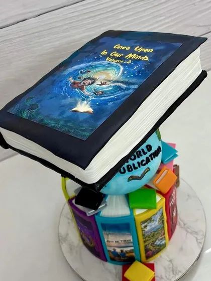 A close-up of the top tier of the book cake, featuring an edible print of the book cover "Once Upon in Our Minds."