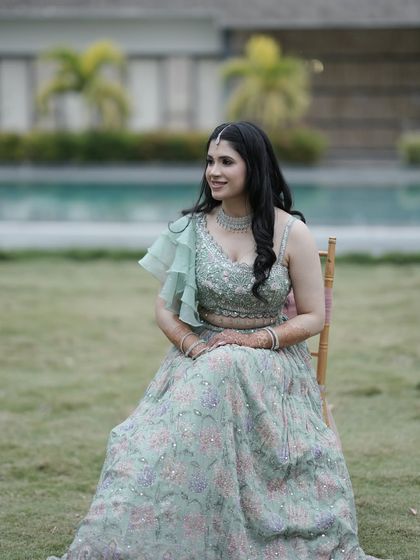 A full-length portrait of the bride in her mint green lehenga, looking serene and elegant.