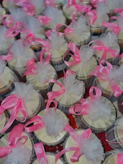 The final packaged look for a large wedding favor order. Each candle is wrapped in tulle with a pink ribbon, creating a soft and romantic presentation.