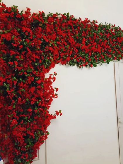 A dense arrangement of artificial red bougainvillea vines. I can install these to frame a doorway or archway, creating a vibrant and welcoming entrance.