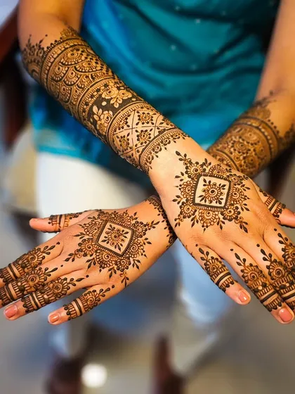A classic crossed-hands pose to display the symmetry and detail of this geometric bridal henna.