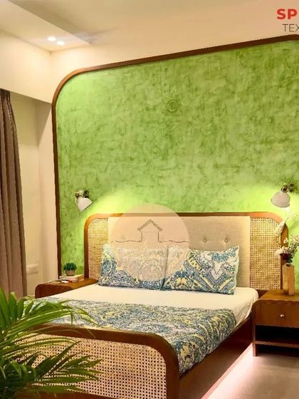 This bedroom is a masterpiece of texture and color. The green feature wall, cane bed frame, and under-bed lighting come together to create a space that is both elegant and deeply comforting.