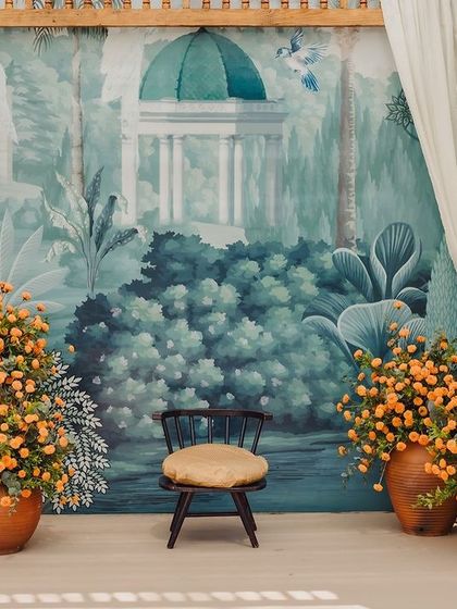 The full setup for a Varapuja ceremony, with a beautiful hand-painted backdrop and an abundance of fresh marigolds.