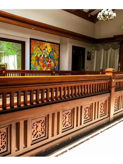 The upper-level gallery overlooking the central living space. The continuous wooden railing, adorned with carved panels, demonstrates our commitment to using craftsmanship to define and enrich interior architecture.