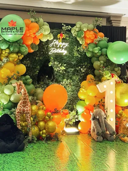 A 'Wild One' jungle safari theme for a memorable first birthday party. We used a rich palette of green and orange balloons, safari animal props, and a custom neon sign to create a fun and adventurous world for the little one.