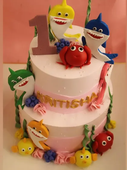 Dive into fun with our popular Baby Shark themed cake. This two-tier creation, made for a first birthday, features vibrant, handcrafted fondant characters from the beloved show, highlighting our skill in creating playful and detailed cakes for children.
