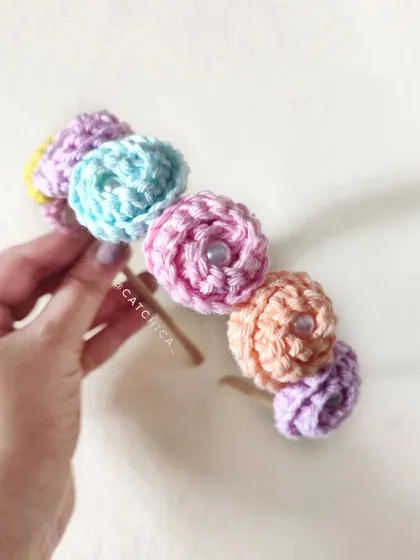 A close-up of the hand-crocheted flowers on our floral tiara. Each flower has a delicate pearl bead in the center.